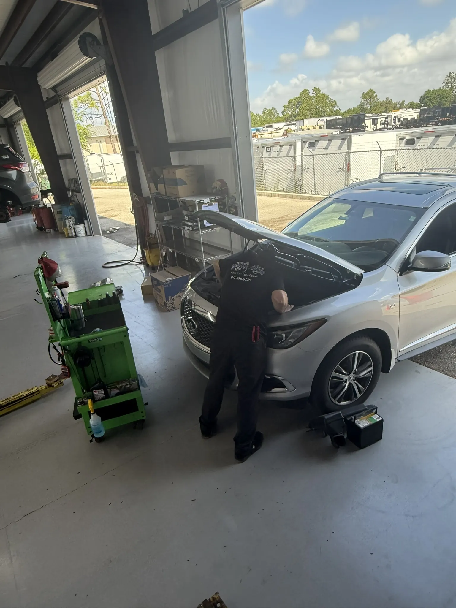 Technician working under the hood of an SUV at St. George Automotive